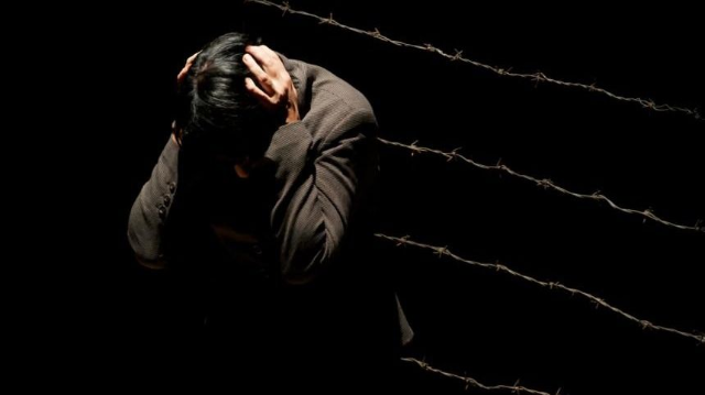 Foto rappresentativa di una persona triste, depressa e sola in un angolo con le mani tra i capelli
